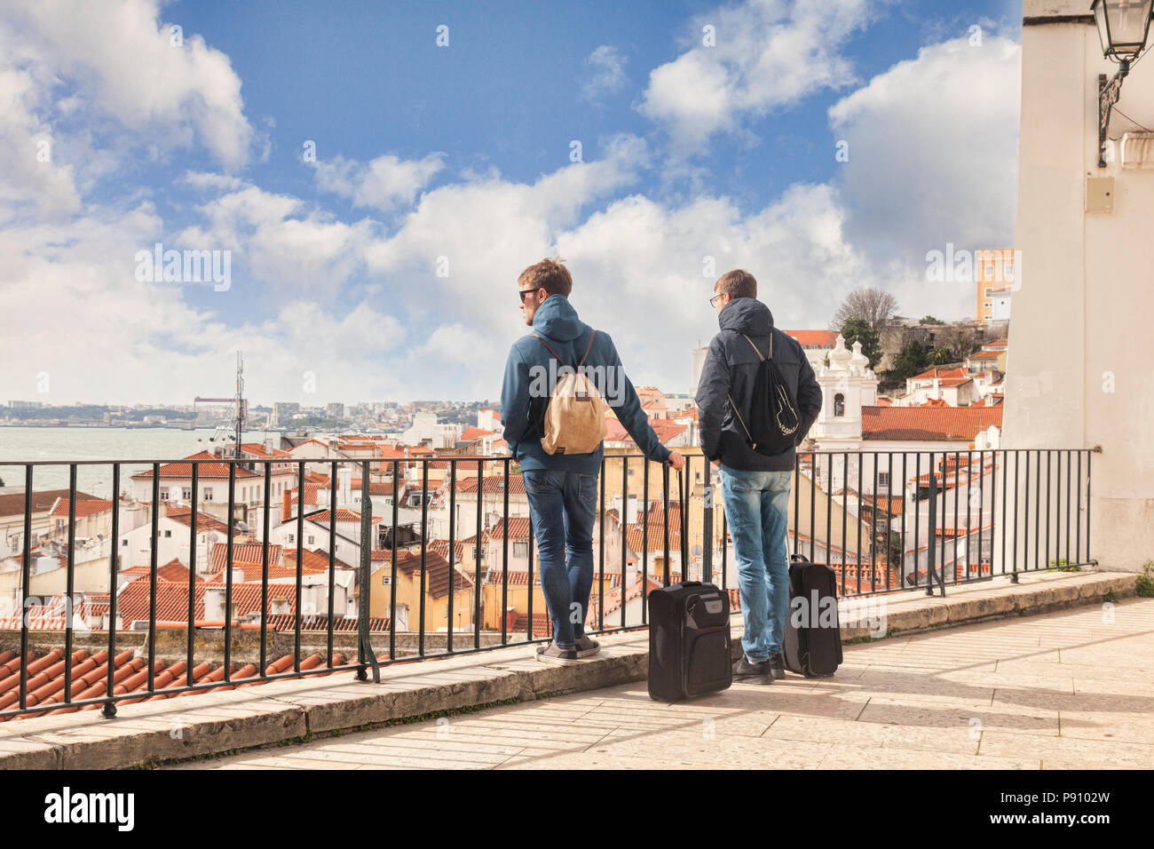 Vom 7. März 2018: Lissabon, Portugal - Zwei junge Männer mit Übertrag auf Gepäck, wenn man die Aussicht auf die Stadt von der Miradouro de Santa Estevao. Stockfoto