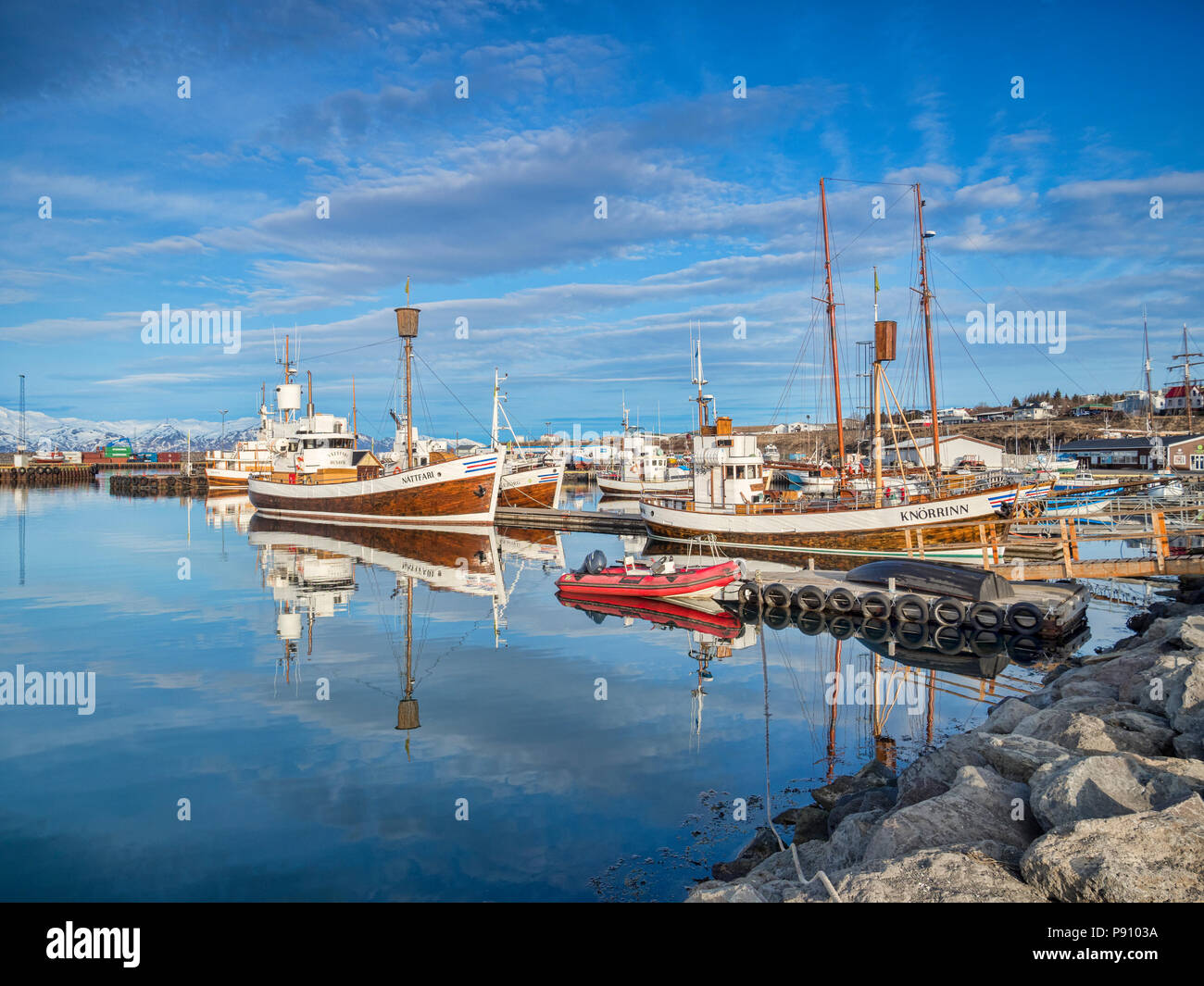 13. April 2018: Husavik, Island. Der Hafen in Husavik im Norden Island, mit Booten, darunter whale-watching Schiffe, die sich in den ruhigen Wasser spiegelt Stockfoto