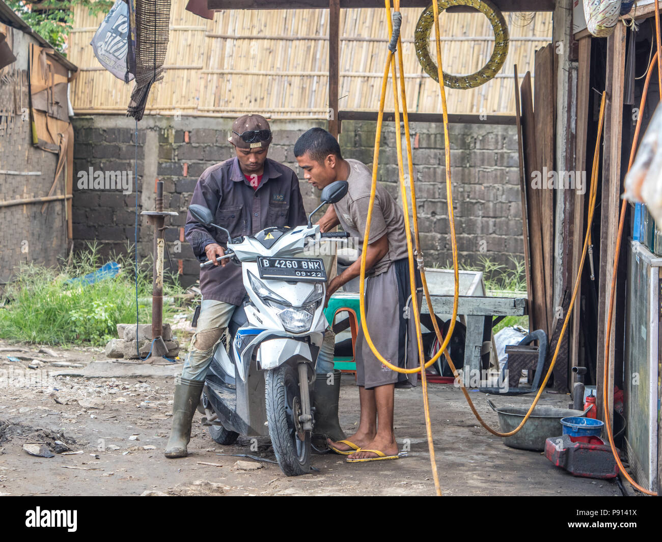 Jakarta, Indonesien - 20. Februar 2018: Der Mann mit der Instandsetzung des Motorrad (ojek) auf den Straßen von Jakarta. Stockfoto