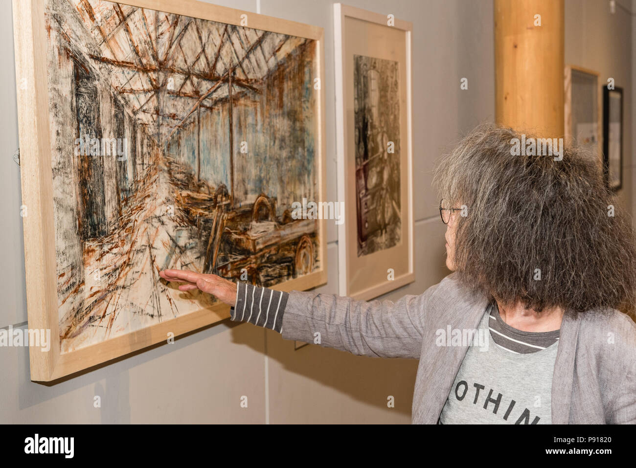 Oriel Môn, Llangefni, Gwynedd, Wales, UK. Freitag, 13. Juli 2018. Die Eröffnung und der Preisverleihung für die hundertjahrfeier und vierten Kyffin Williams Zeichnung Preis Ausstellung, die von ITV Cymru Wales und Rogers Jones Auktionatoren gesponsert, wurde am Erker Môn gehalten, mit Künstler Gilly Thomas bewundern die Arbeit von Gwynedd Künstlerin Louise Morgan Credit: Michael Gibson/Alamy leben Nachrichten Stockfoto