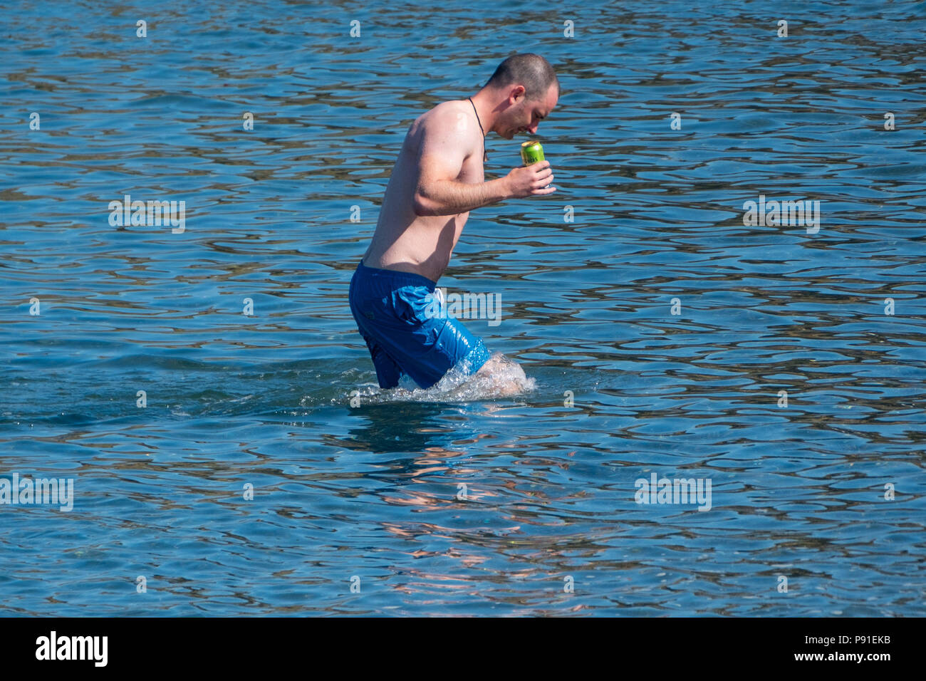 Aberystwyth Wales UK, Samstag, 14. Juli 2018 UK Wetter: Leute an den Strand und das Meer auf eine helle und sehr warmen und sonnigen Samstag Morgen in Aberystwyth an der Westküste von Wales. Die lange Zeit der heißen und ungewöhnlich trockene Wetter fort, wobei die Temperaturen wieder auf über 30 °C klettern in Teilen des Vereinigten Königreichs dieses Wochenende Foto: Keith Morris/Alamy leben Nachrichten Stockfoto
