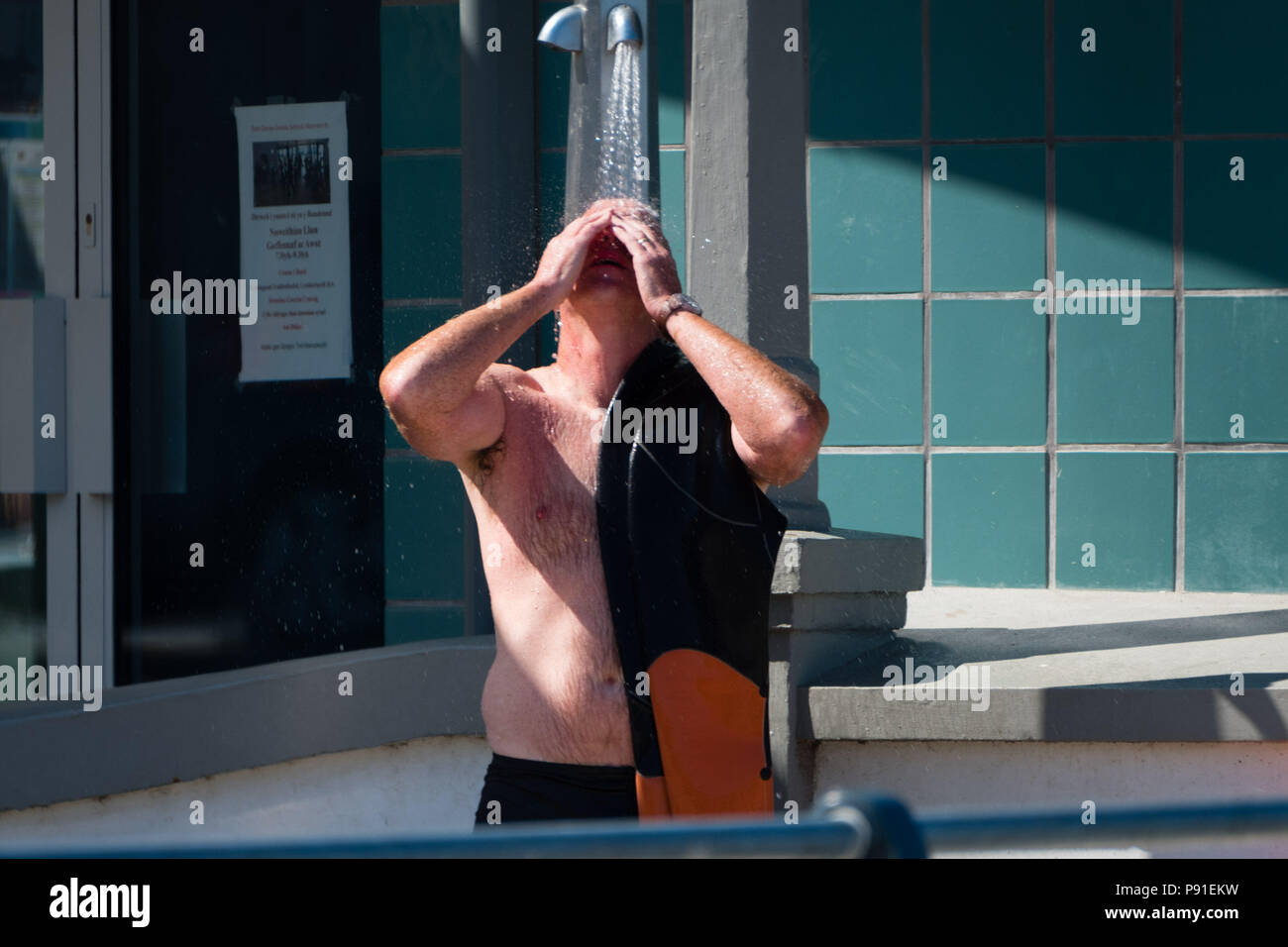 Aberystwyth Wales UK, Samstag, 14. Juli 2018 UK Wetter: Leute an den Strand und das Meer auf eine helle und sehr warmen und sonnigen Samstag Morgen in Aberystwyth an der Westküste von Wales. Die lange Zeit der heißen und ungewöhnlich trockene Wetter fort, wobei die Temperaturen wieder auf über 30 °C klettern in Teilen des Vereinigten Königreichs dieses Wochenende Foto: Keith Morris/Alamy leben Nachrichten Stockfoto