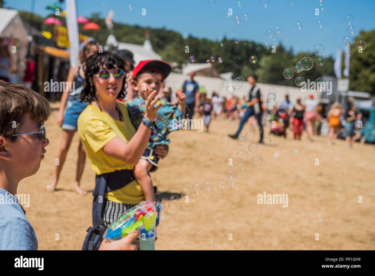 Suffolk, Großbritannien, 14. Juli 2018. Kinder und Erwachsene werden von der riesigen Blasen aus Bubble Inc - Die 2018 Latitude Festival, henham Park unterhalten. Suffolk vom 14. Juli 2018 Credit: Guy Bell/Alamy leben Nachrichten Stockfoto
