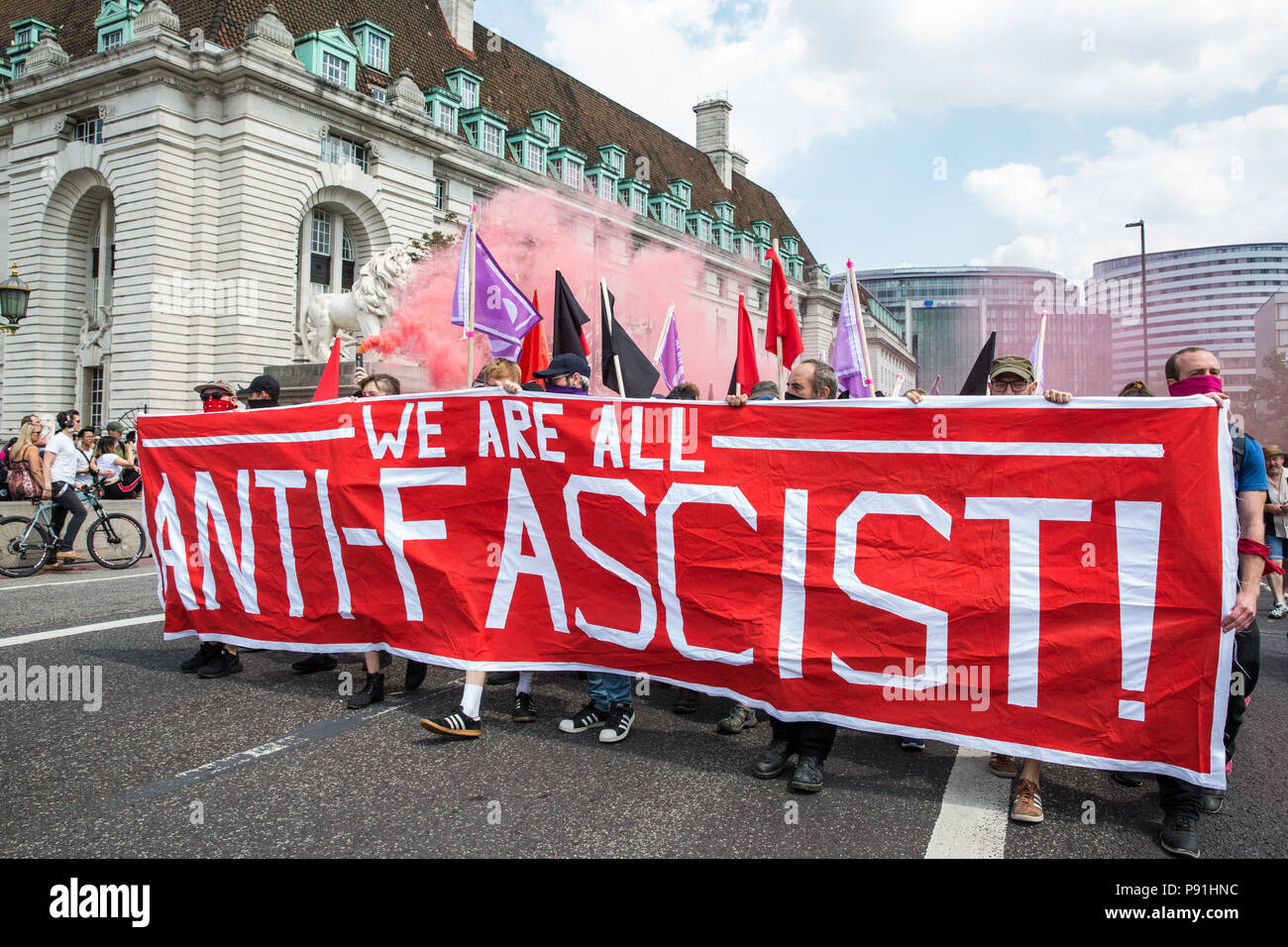 London, Großbritannien. 14. Juli 2018. Antifaschisten halten Rauch Granaten wie Sie März über die Westminster Bridge der rechtsextremen "Freien Tommy' (Robinson) und Trump Anhänger '' Willkommen Märsche Trump' zu erheben. Es gab einige Auseinandersetzungen, wie die anti-faschistischen März wurde von Freien Tommy Anhänger am Rande des Parliament Square angegriffen. Credit: Mark Kerrison/Alamy leben Nachrichten Stockfoto