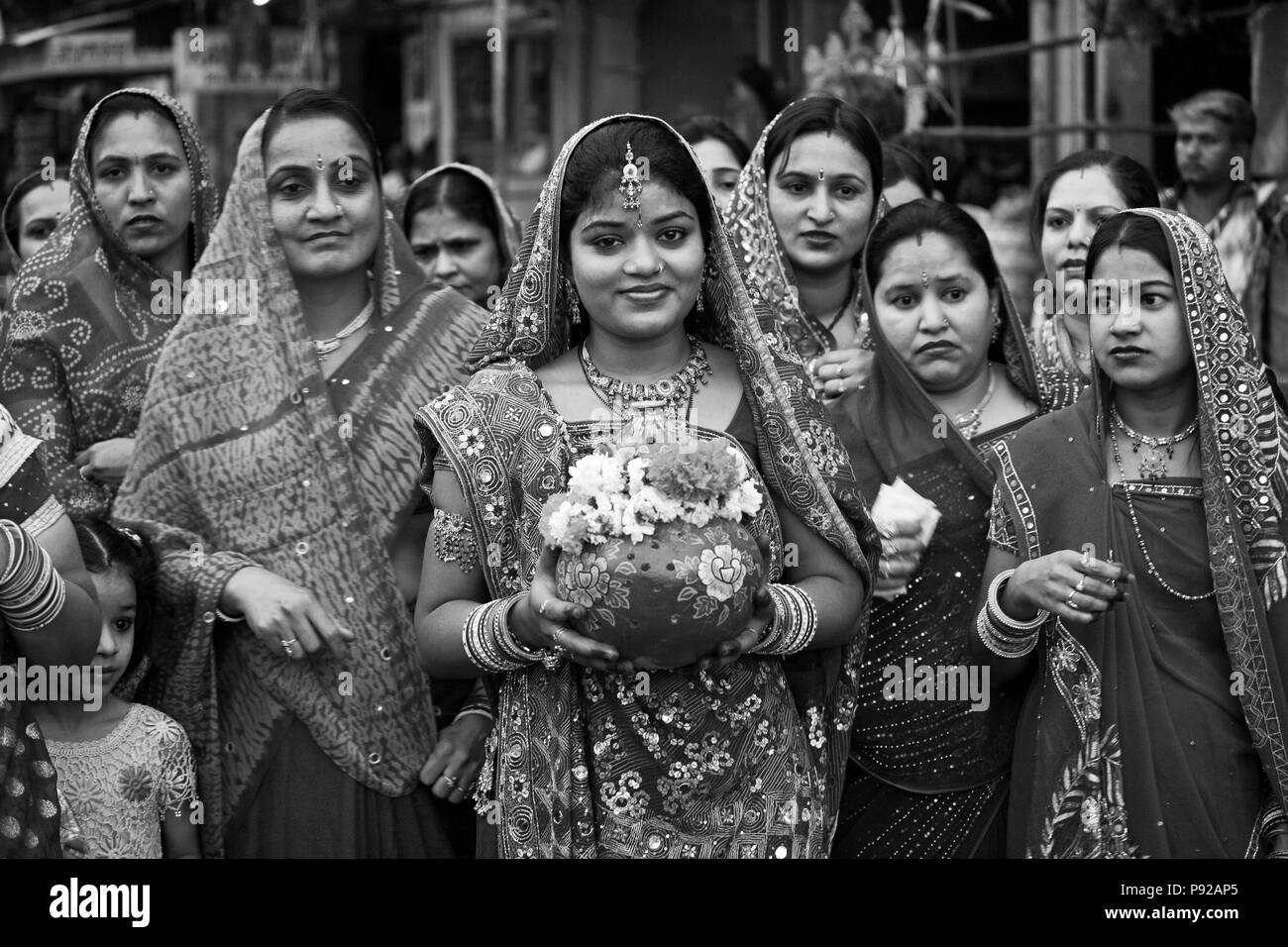 Rajasthani Frauen tragen ein irdenes Gefäß durch die Stadt als Teil der GANGUR JOHDPUR-Festival in Rajasthan, Indien Stockfoto