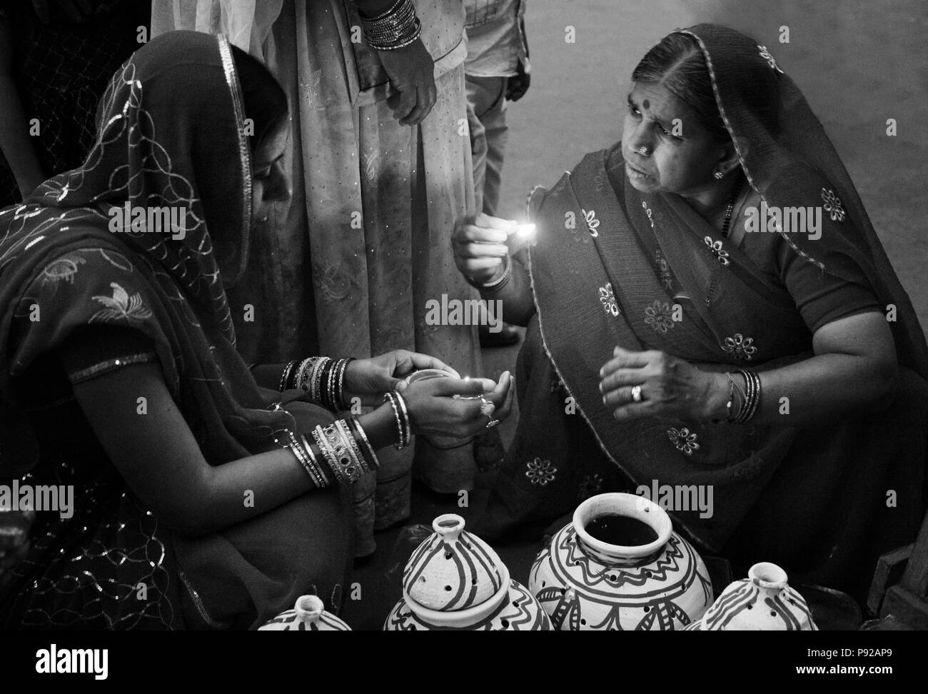 Rajasthani Frauen setzen eine Kerze im Tontopf als Teil der GANGUR JOHDPUR-Festival in Rajasthan, Indien Stockfoto
