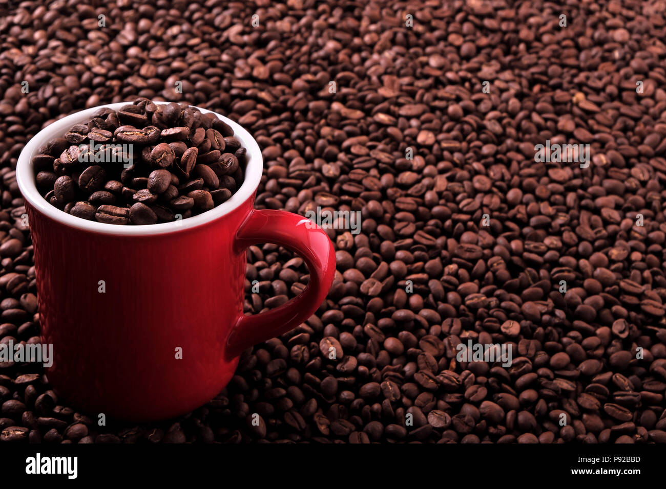 Rote Kaffeetasse mit Bohnen Hintergrund Stockfoto