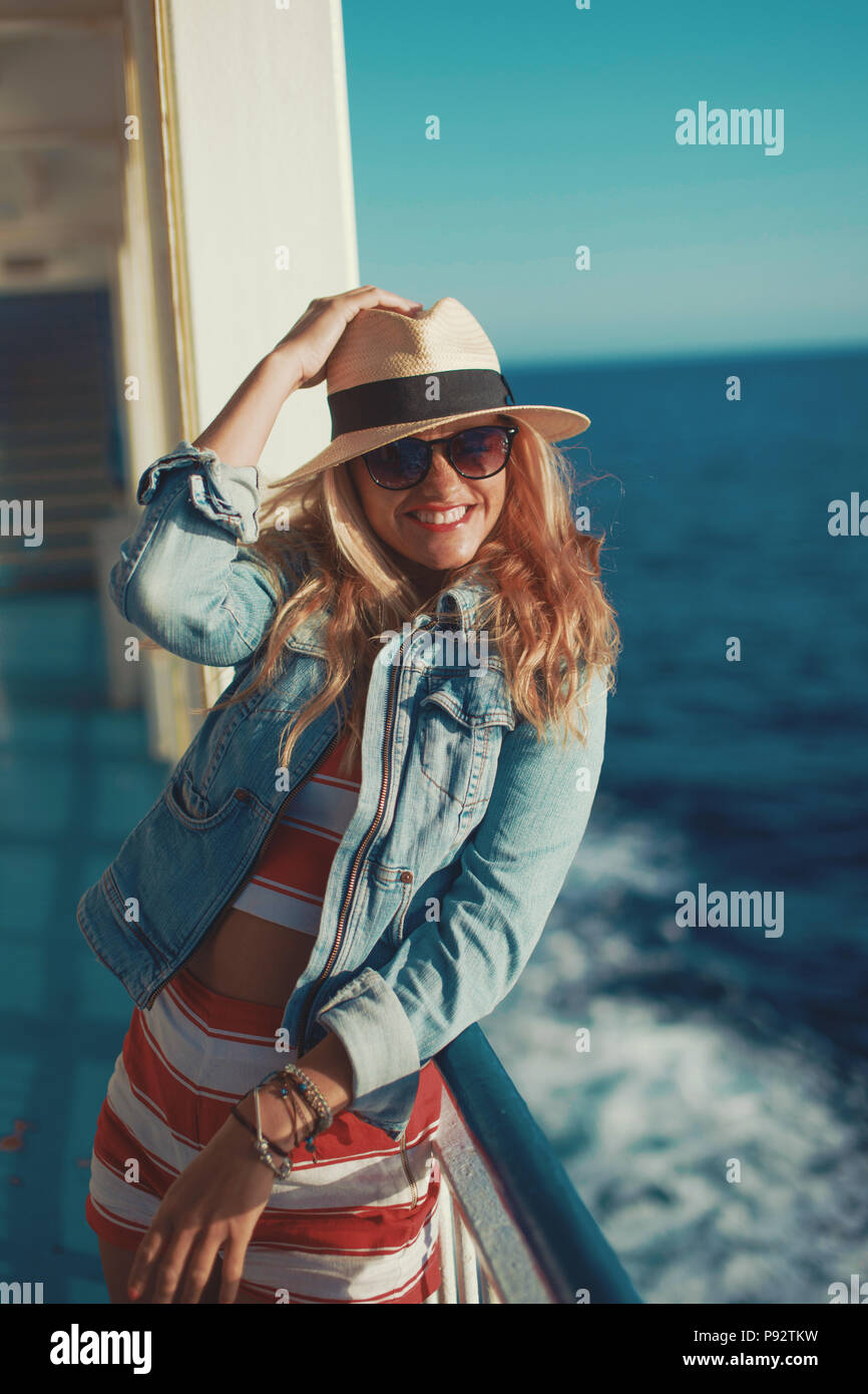 Glückliche junge Reisende Frau in Hut toothy Lächeln auf Kreuzfahrtschiff Stockfoto