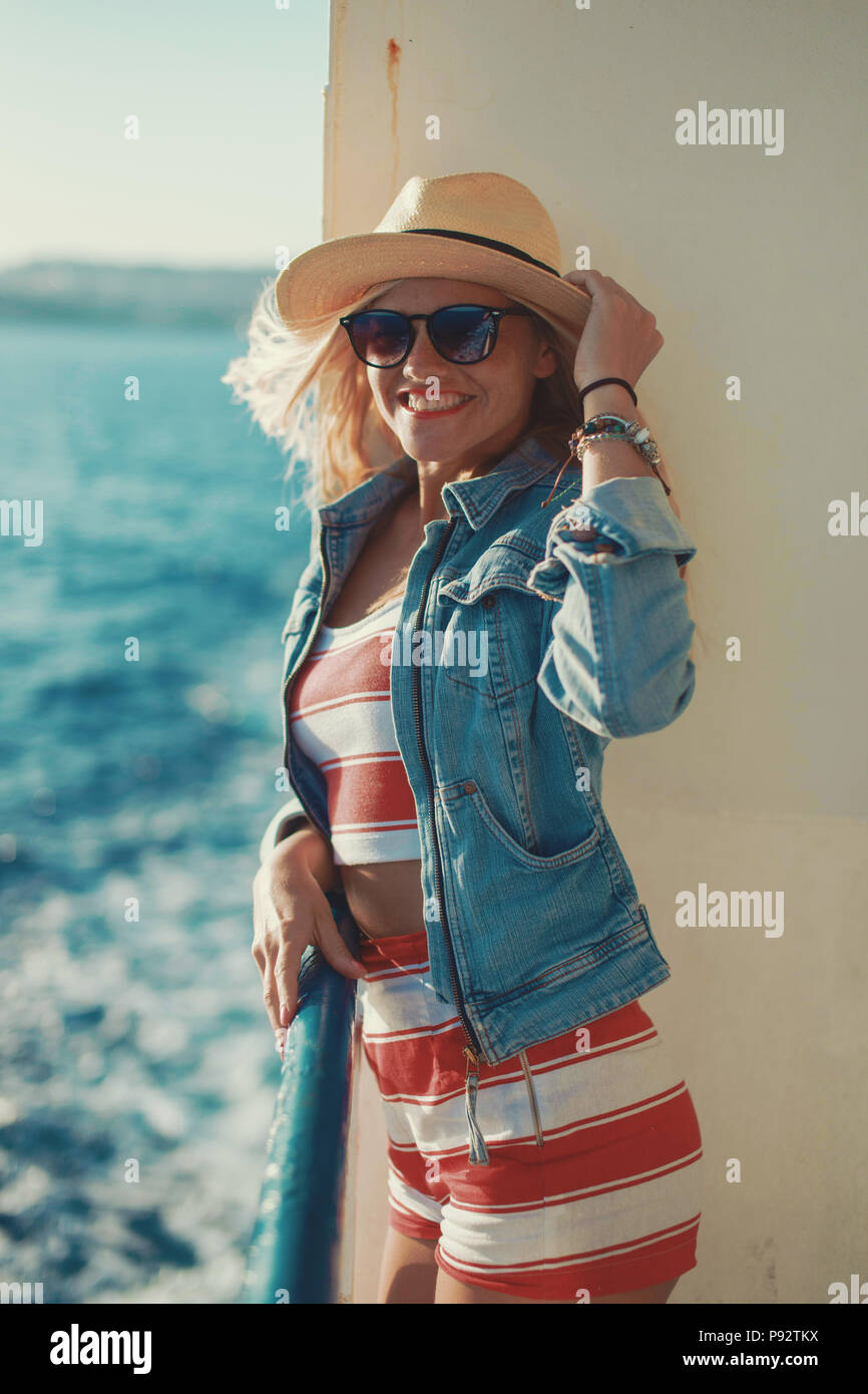 Glückliche junge Reisende Frau mit Hut auf dem Kreuzfahrtschiff Stockfoto