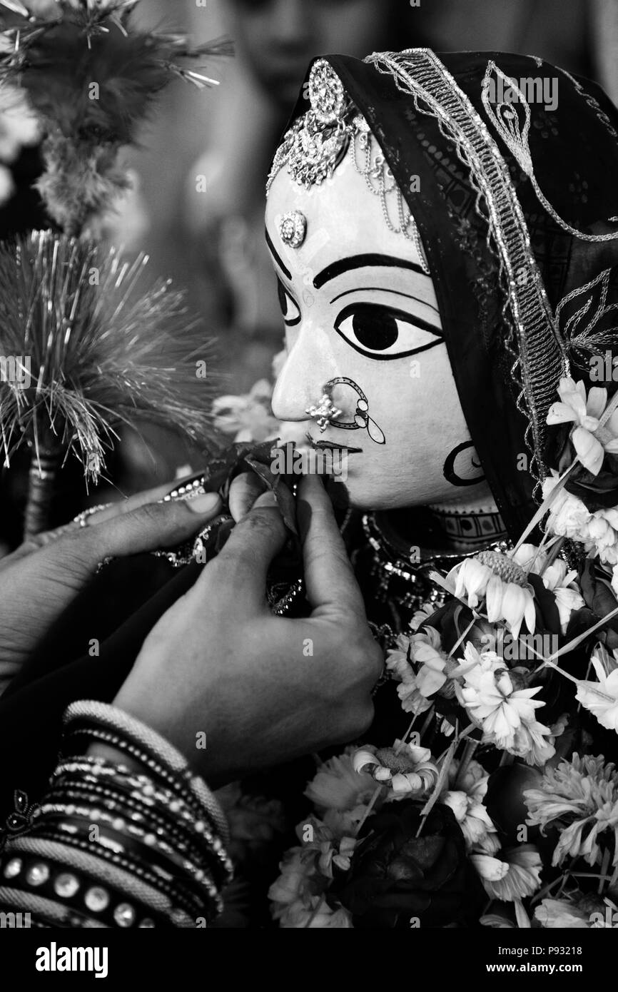 Ein Rajasthani Frau macht eine Blume offerting zu Shiva's Frau PARVATI am GANGUR FESTIVAL auch als der MEWAR FESTIVAL in Udaipur, Rajasthan, IN bekannten Stockfoto