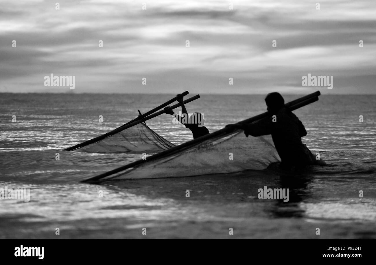 Ein Fischer Pflüge sein Netz ins Meer, um Fische - ANDAMAN SEA, THAILAND zu fangen Stockfoto