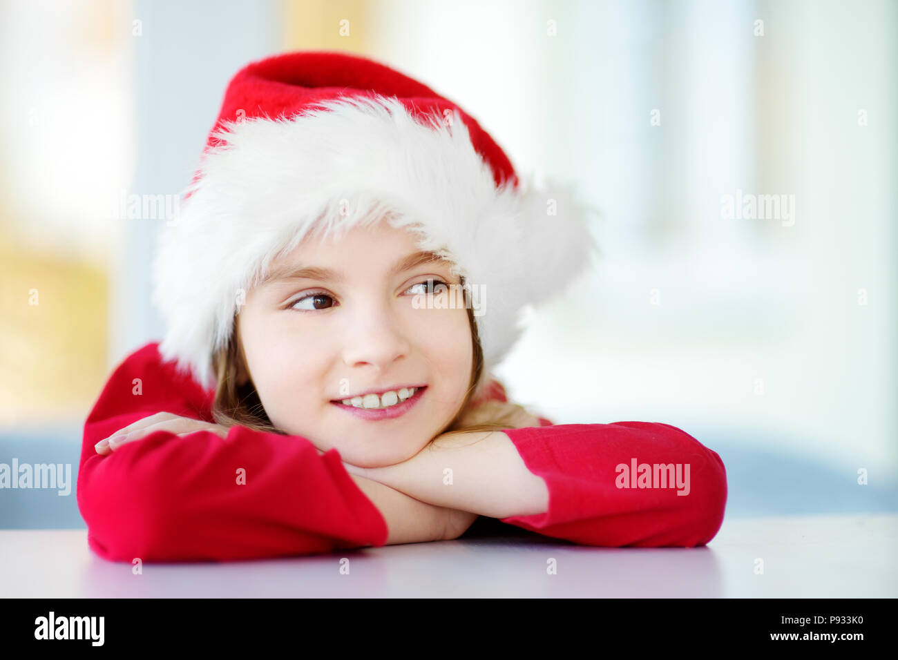 Adorable kleine Mädchen mit Santa Hut auf Weihnachten Morgen. Feiern Weihnachten zu Hause. Stockfoto