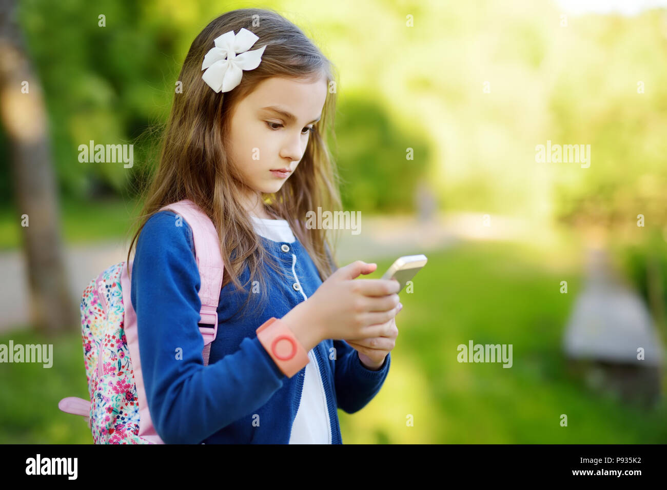 Adorable kleine Mädchen, die ein Foto mit einem Smartphone auf schönen Sommertag. Kinder mit mobilen Geräten. Stockfoto