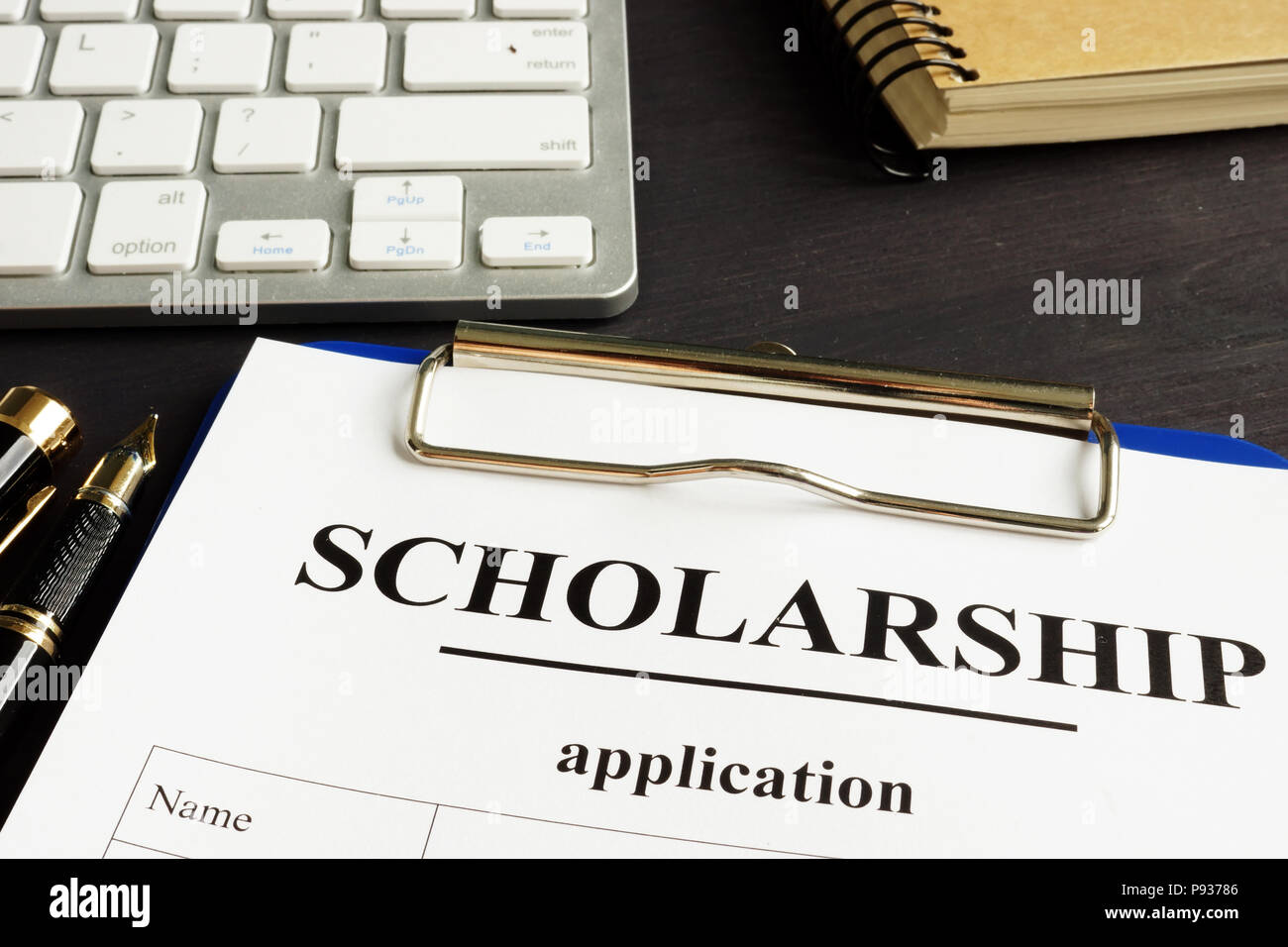 Bewerbung um ein Stipendium und Geld für Bildung auf einen Tisch. Stockfoto