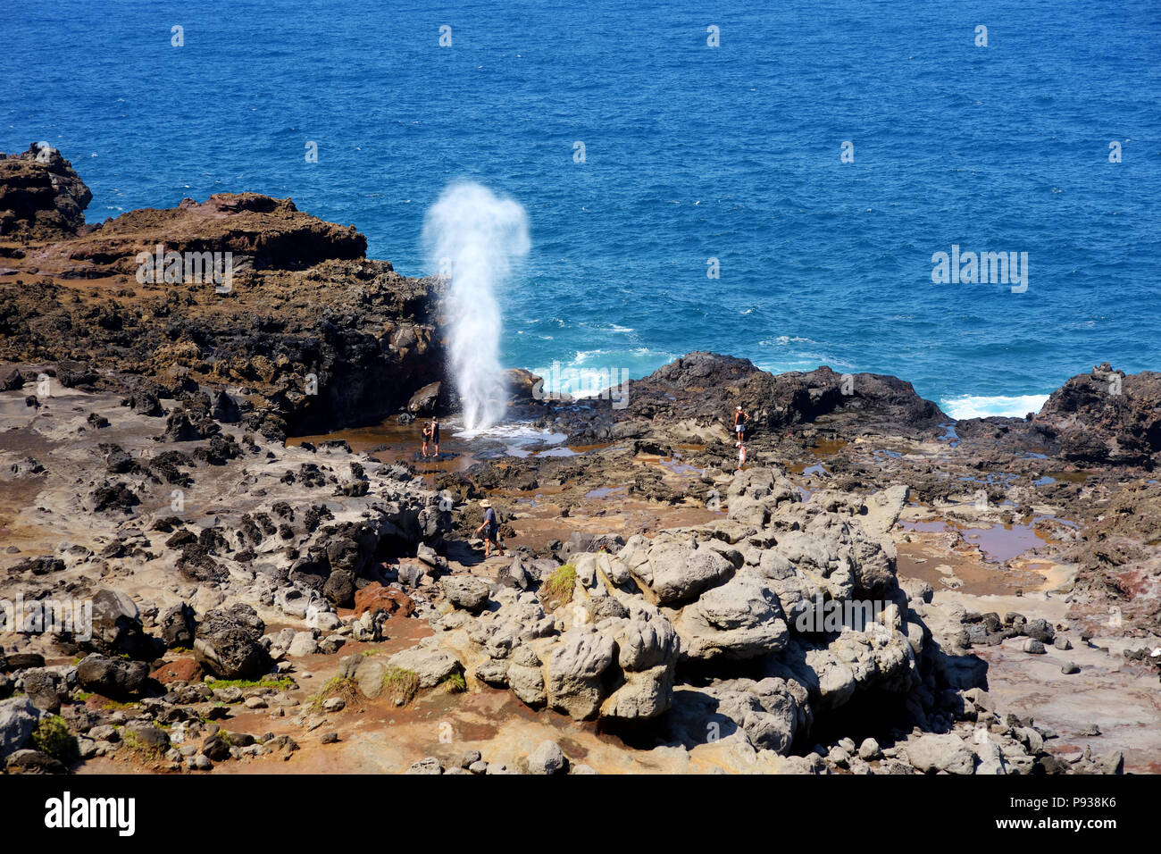 Touristen bewundern die Nakalele blowhole an der Küste von Maui. Ein Strahl von Wasser und Luft ist heftig, durch das Loch in den Felsen gezwungen. Hawaii, U Stockfoto