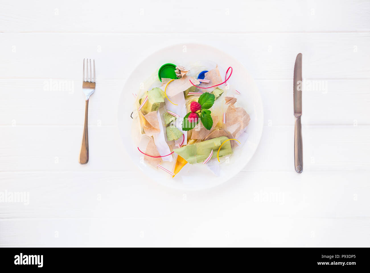 Messer und Gabel Platte mit unreal Salat aus Recycling von Abfällen, synthetische Inhaltsstoffe. Konzept der Künstlichen, Essen. Gvo, E-Nummern Chemikalien in der Nahrung Stockfoto
