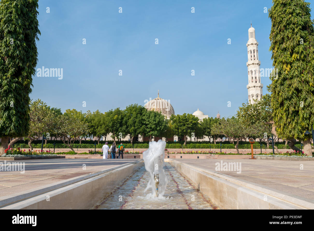 Die Besucher der Sultan Qaboos Grand Mosque in Maskat, Oman, wandern durch die formale Gärten in Richtung Main Gebetsraum Stockfoto