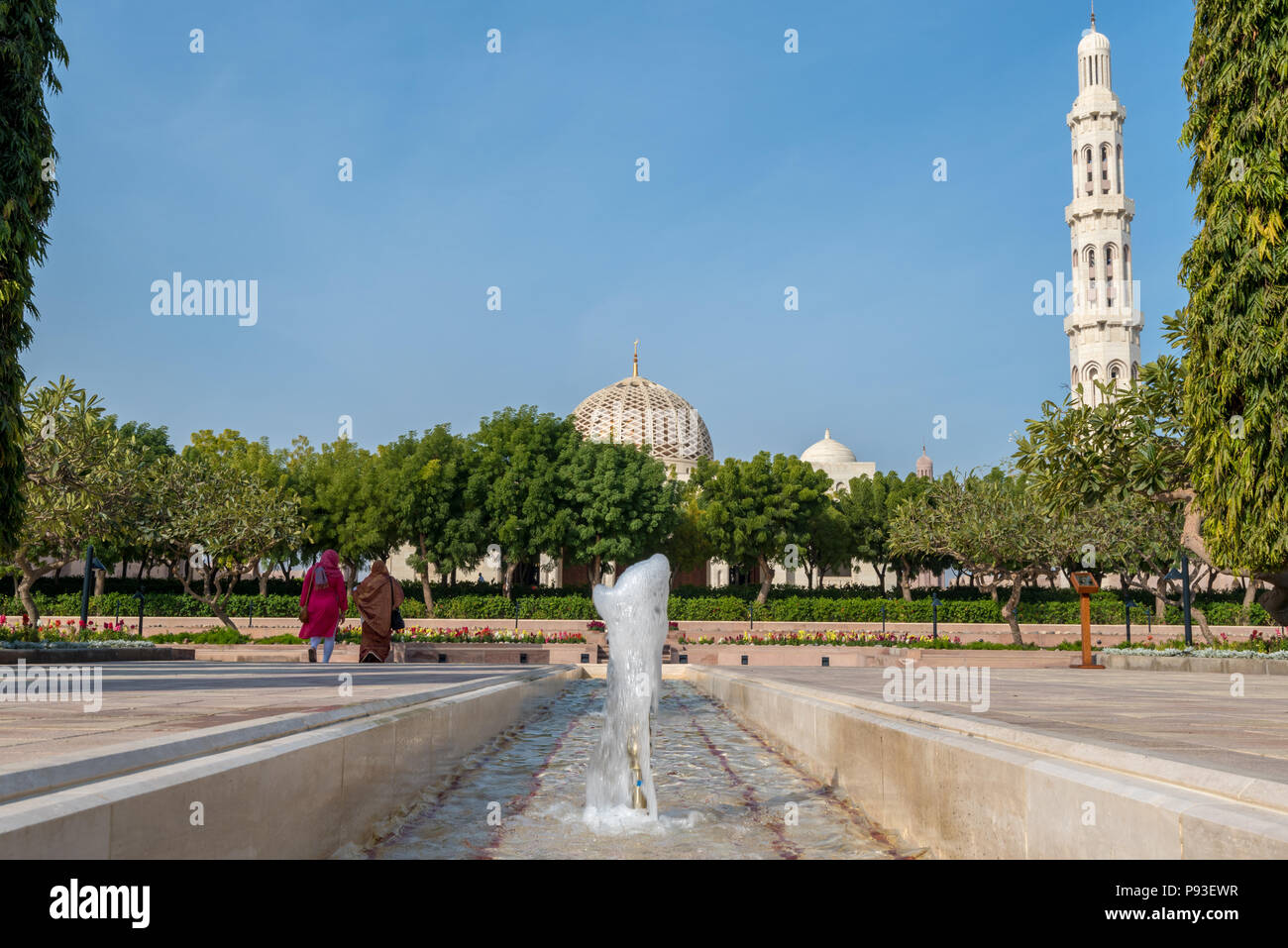 Die Besucher der Sultan Qaboos Grand Mosque in Maskat, Oman, wandern durch die formale Gärten in Richtung Main Gebetsraum Stockfoto