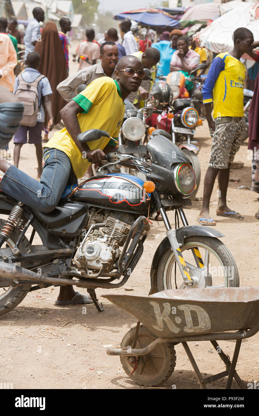 Kakuma, Kenia - Straßenszene mit Menschen und Motorräder. Motorrad Verkehr auf einem langen unbefestigten Straße. Stockfoto
