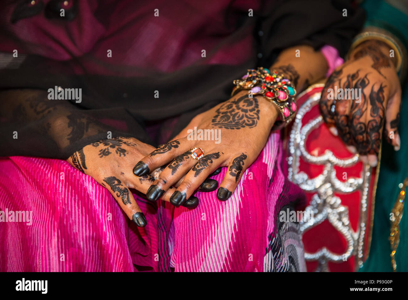 Schwarzes Henna Hands Zeichnungen auf Frauen für afrikanische Hochzeitsfeier mit großen Ringen Stockfoto