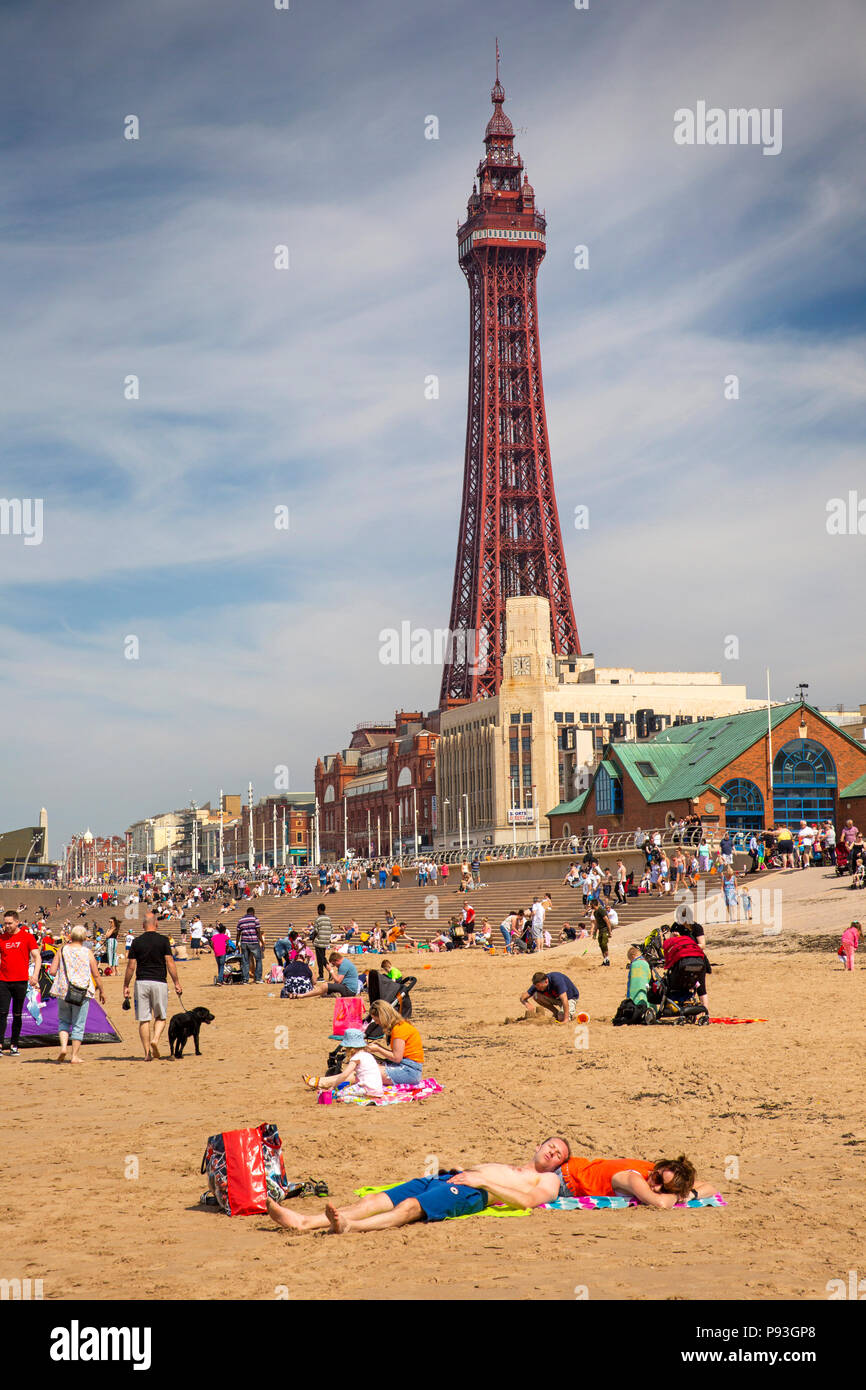 Großbritannien, England, Lancashire, Blackpool, Besucher entspannen in der Sonne am Strand unterhalb der Blackpool Tower Stockfoto