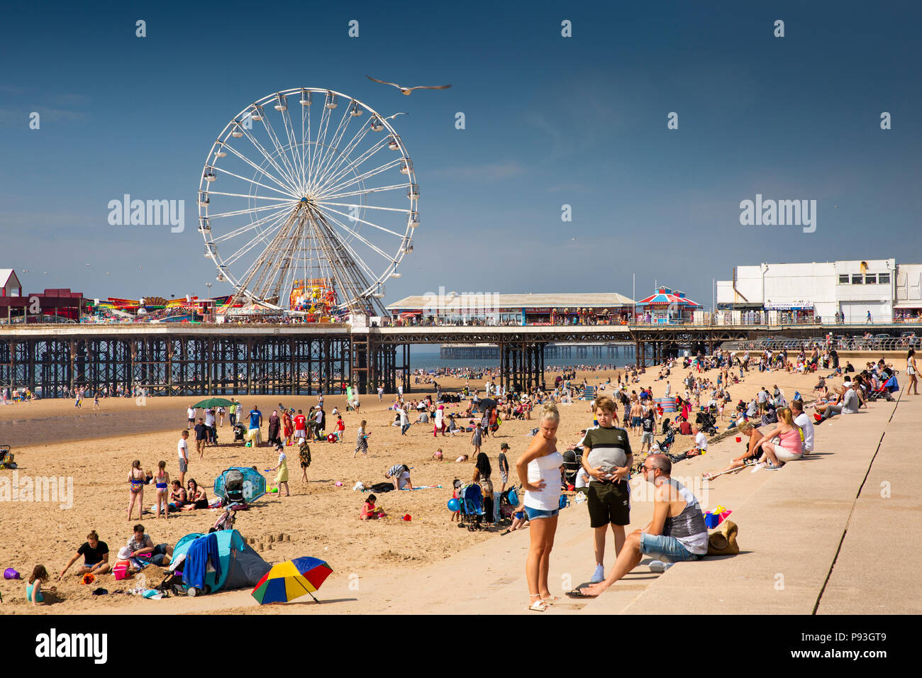 Großbritannien, England, Lancashire, Blackpool, Besucher entspannen in der Sonne am Strand von Central Pier Stockfoto