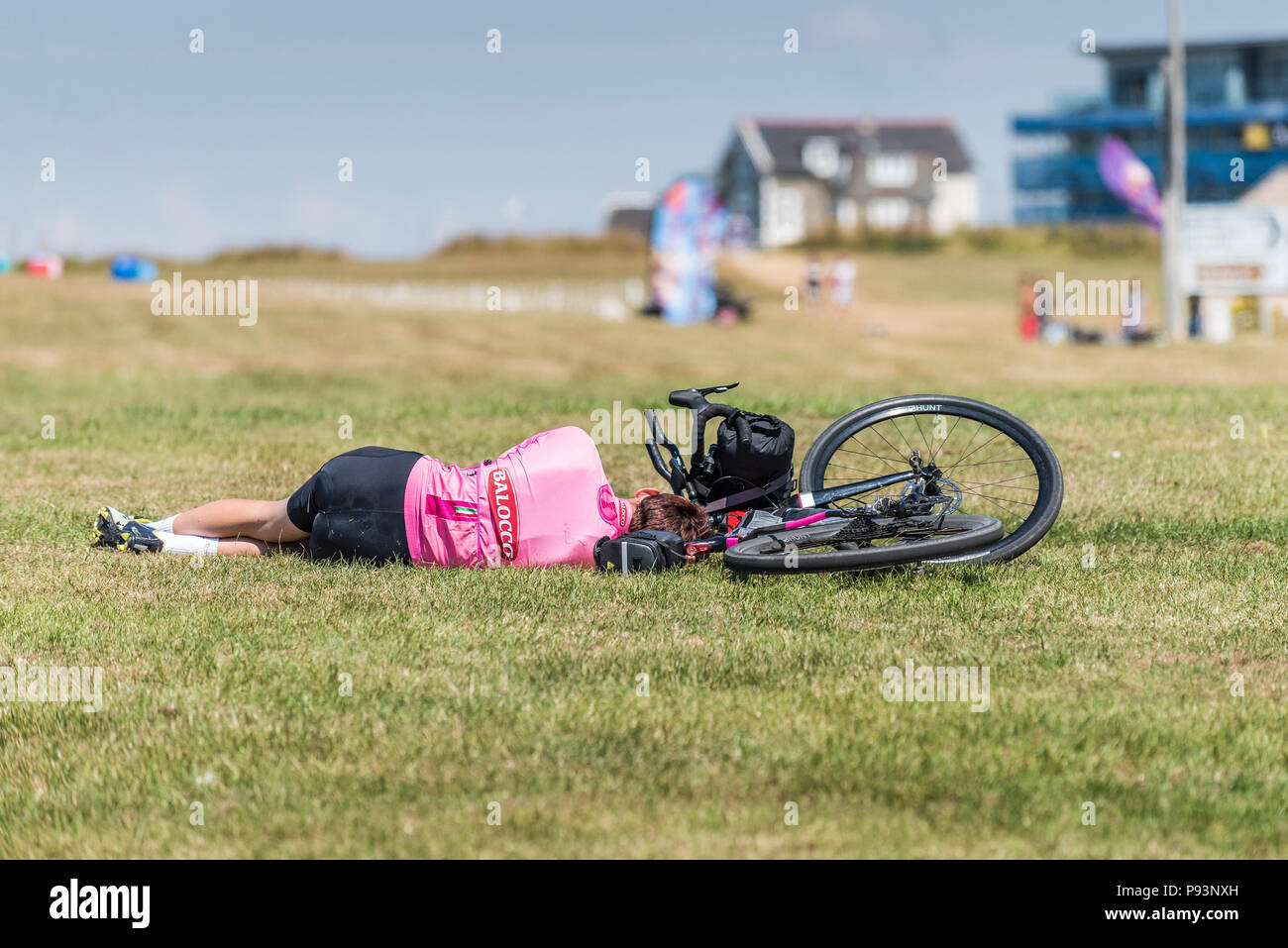 Ein müder Radfahrer schläft auf einem Feld. Stockfoto