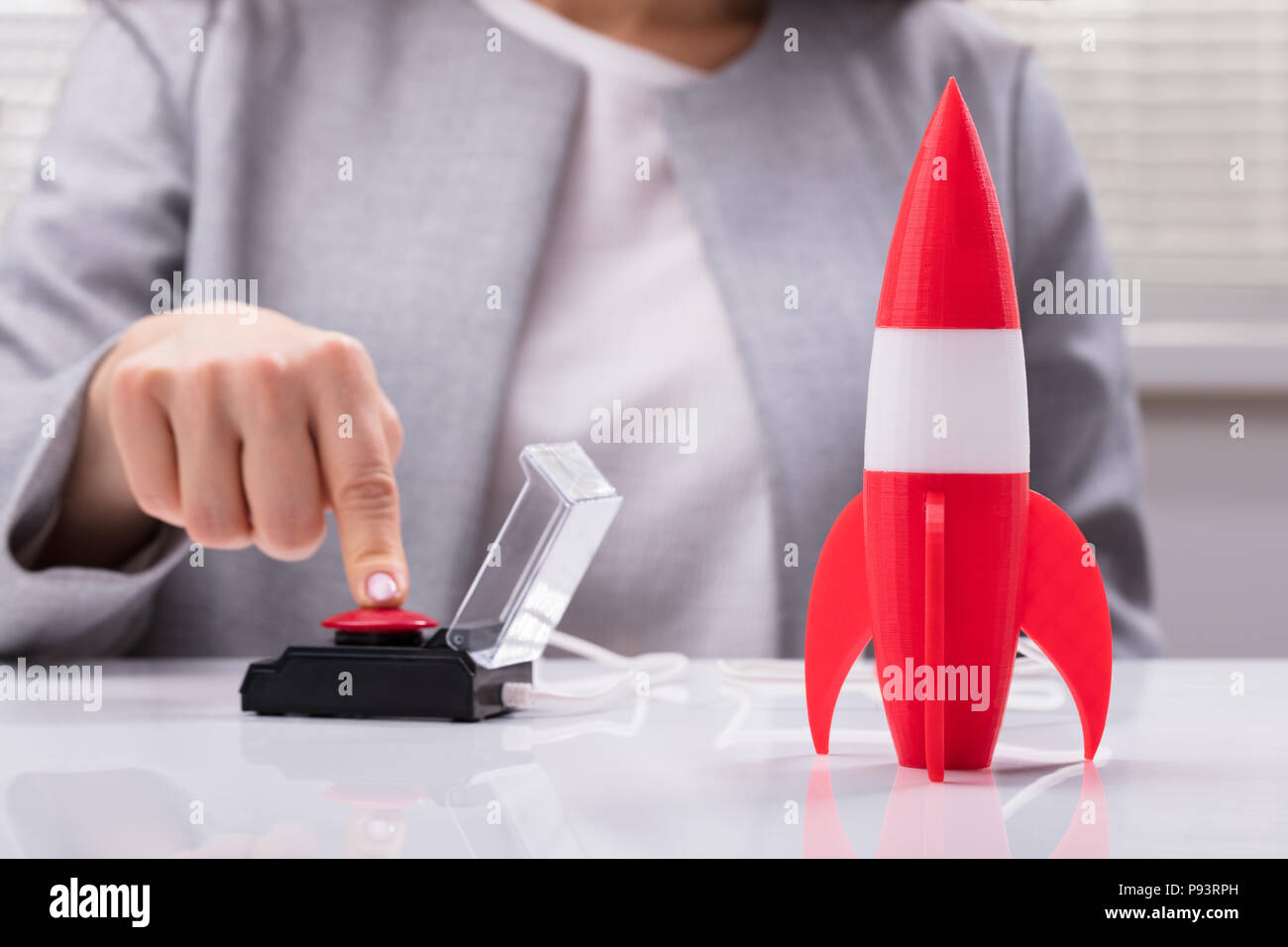 Die Geschäftsfrau Hand mit Raketen durch Drücken der roten Taste Stockfoto