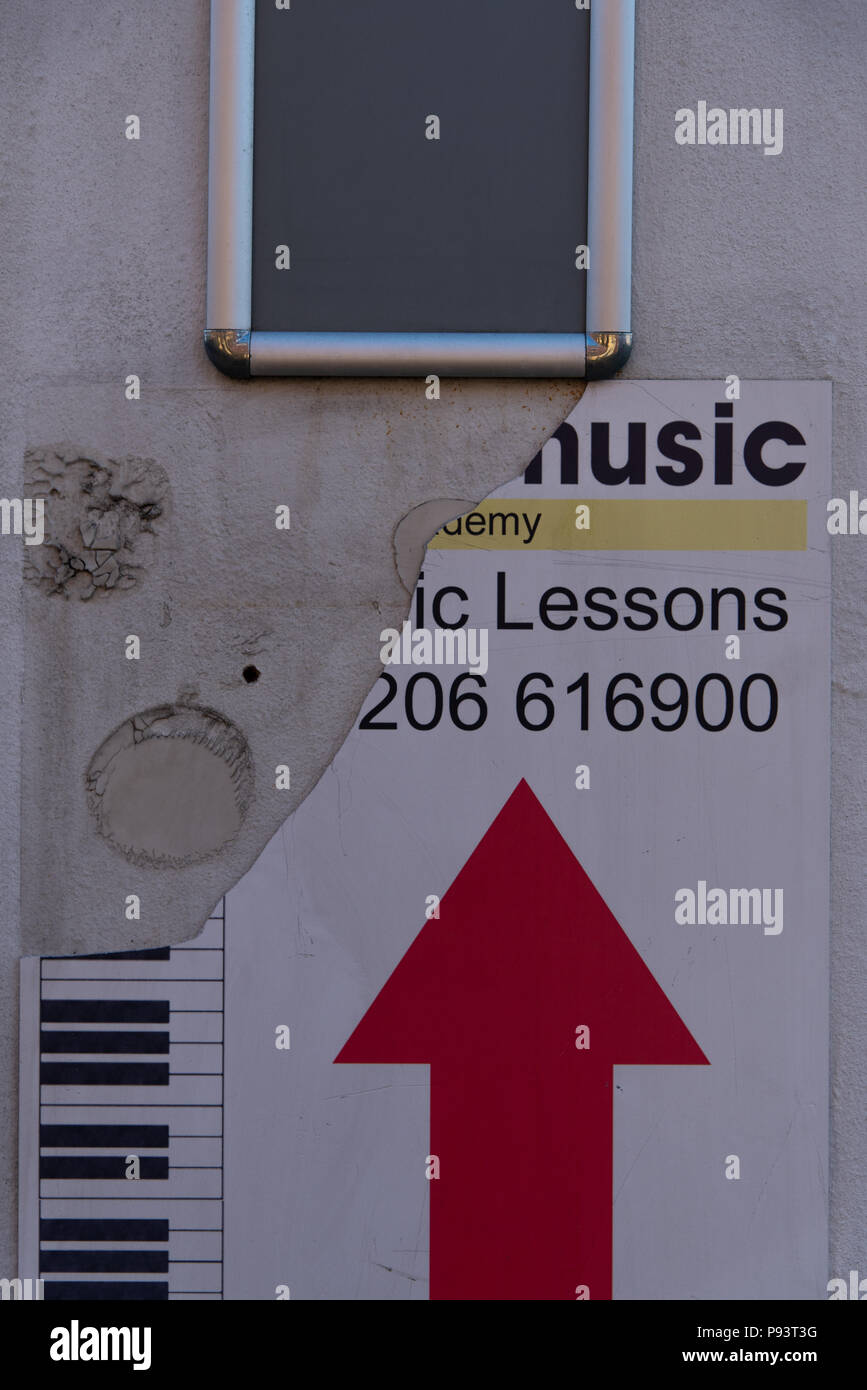 Beschädigte Zeichen Werbung Musikunterricht mit einem roten Pfeil und ein Teil der Tastatur. Stockfoto