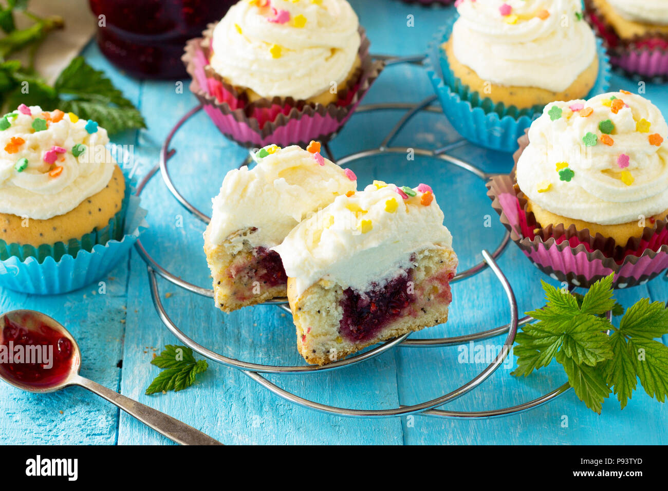 Bunte orange Cupcake Geburtstag mit himbeermarmelade Close-up auf einem Holztisch. Stockfoto
