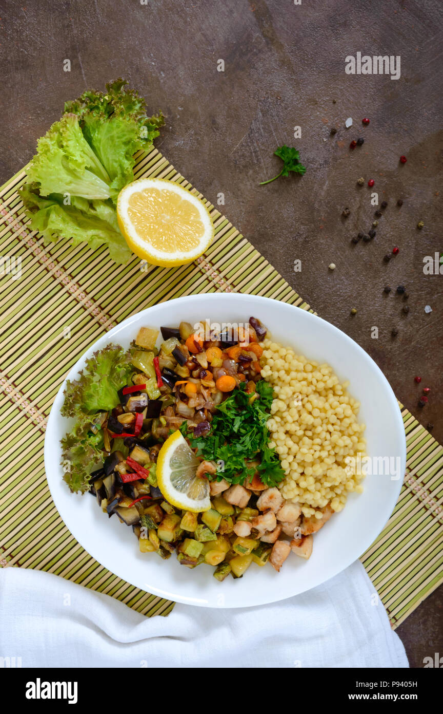 Köstliche orientalische Salat tabbouleh. Couscous mit gebratenem Gemüse und Huhn auf einem weißen Teller. Traditionelle libanesische Vorspeisen. Stockfoto
