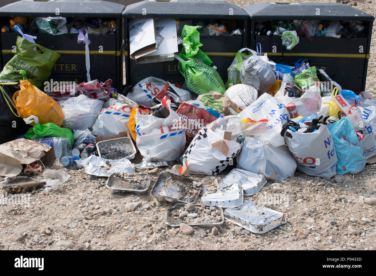 Überquellenden Mülltonnen am Strand mit Blauer Flagge, Hayling Island, Hampshire, nach einem sonnigen Wochenende Stockfoto