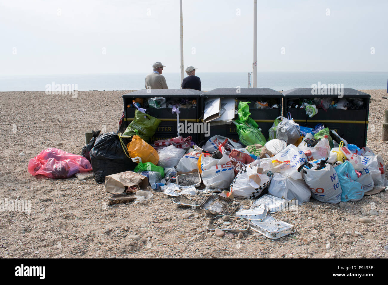 Überquellenden Mülltonnen am Strand mit Blauer Flagge, Hayling Island, Hampshire, nach einem sonnigen Wochenende Stockfoto