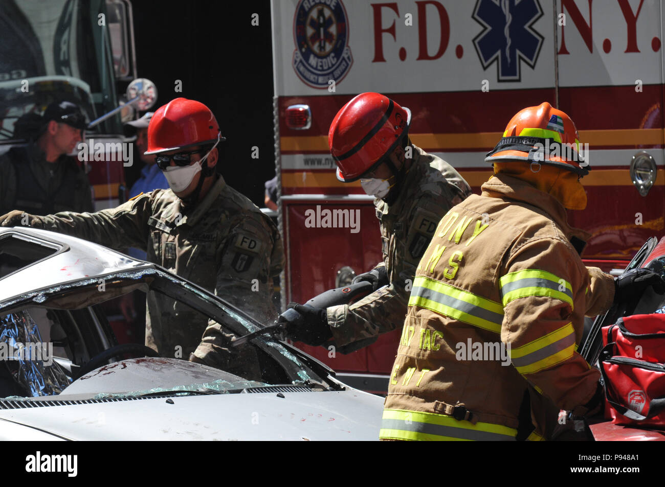 468th Engineer Detachment ist eine Feuerwehreinheit der US Army Reserve, die neben der Feuerwehr der Stadt New York arbeitet. Das Archivbild dokumentiert die Beobachtung eines Fahrzeugextrikationsverfahrens während einer gemeinsamen CBRN-Trainingsübung an der Times Square Church in New York City am 10. Juli 2018. Stockfoto