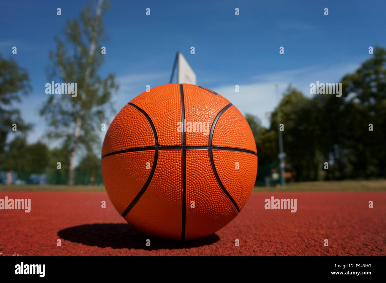 Basketball auf outdoor Basketball Boden vor den Bäumen und blauen bewölkten  Himmel. Kostenlose Kopie Stockfotografie - Alamy