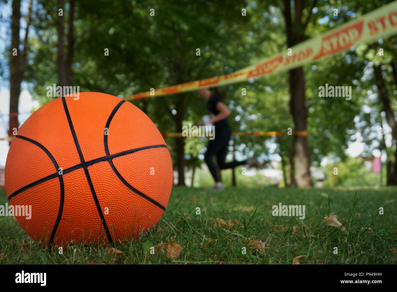 Nahaufnahme einer Orange traditionelle 8-panel Basketball auf dem grünen Rasen draußen im Park in einem Sommertag Stockfoto