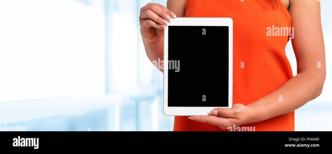 Technologie Werbebanner - Frau in orange Kleid mit perfekten Fingernägeln halten digitale Tablette mit leeren Bildschirm (Kopie). Stockfoto