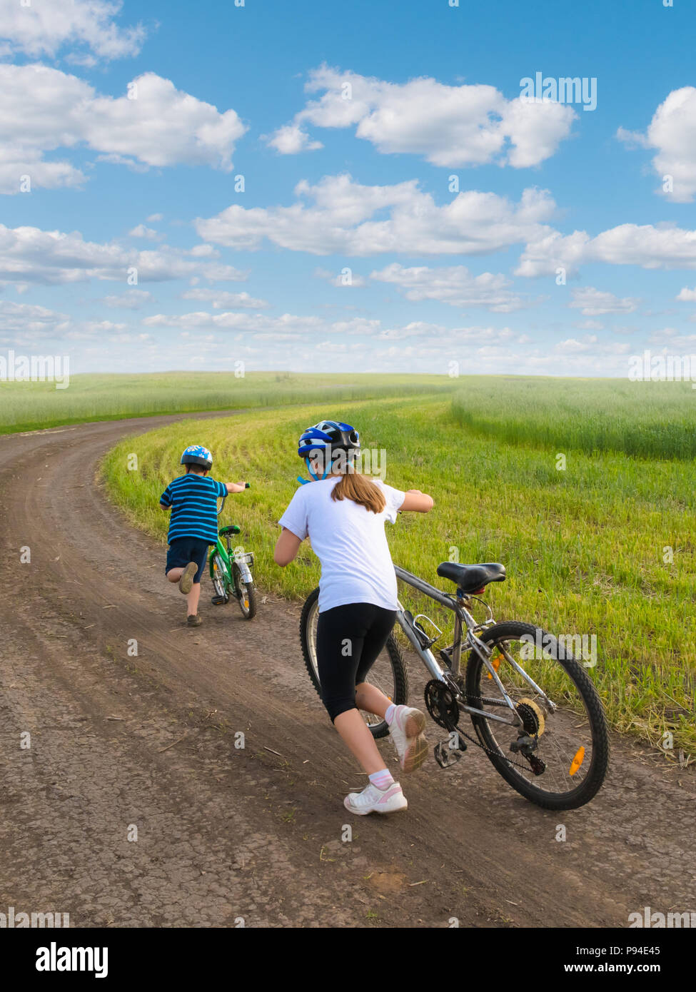 Sportliche Kinder bergauf mit Fahrrädern Stockfoto