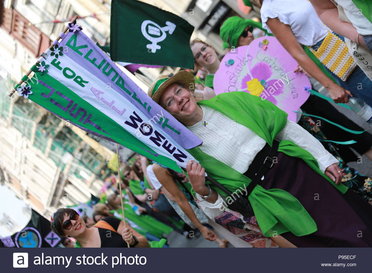 Eine Frau lächelt beim Gehen nach Westminster zu Ehren der suffragetten Stockfoto