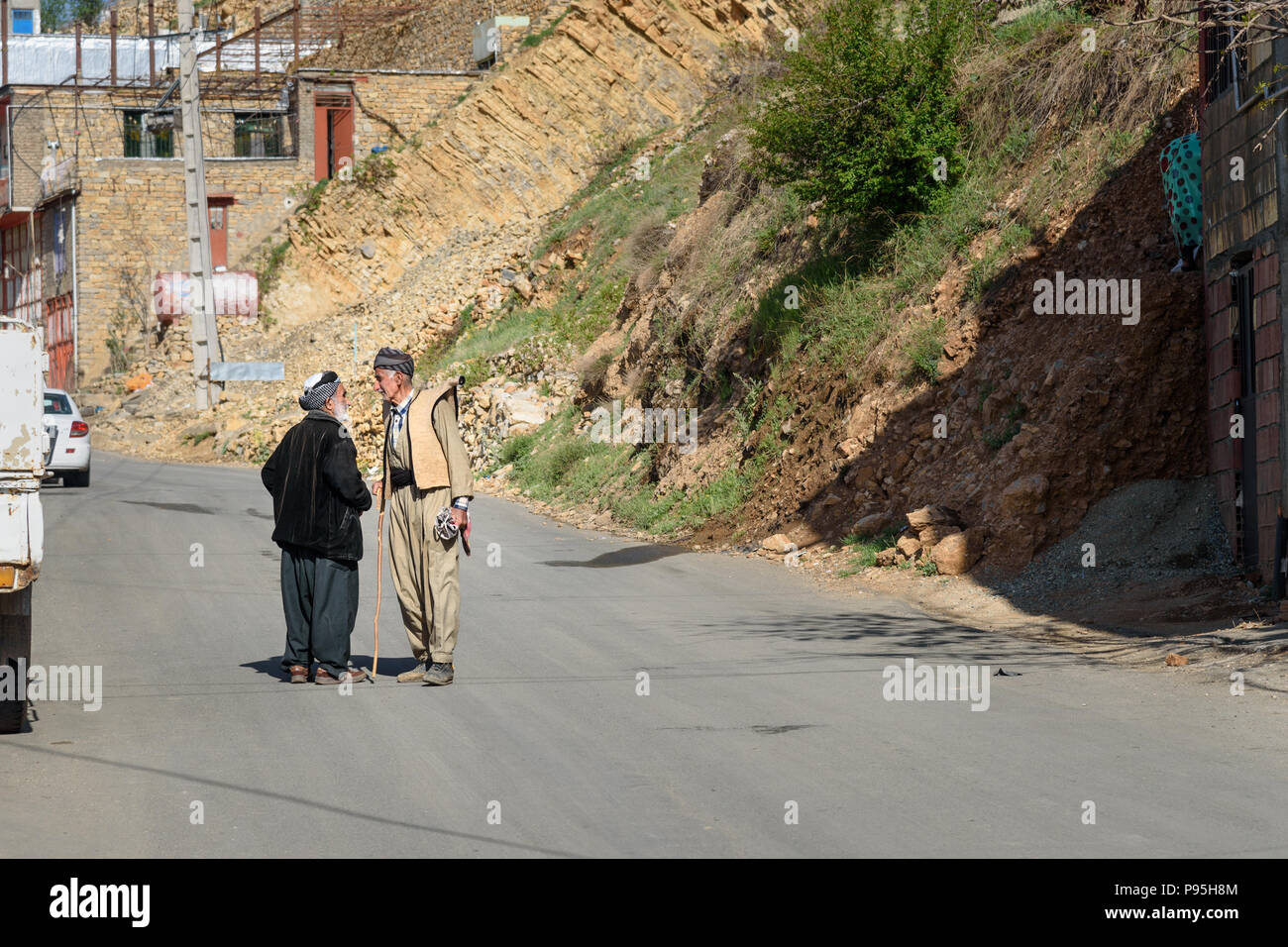 Howraman, Provinz Kurdistan, Iran - April 5, 2018: Kurdische Männer in traditioneller Kleidung auf der Straße von Howraman Dorf oder Uraman Takht in Zagros Mo Stockfoto