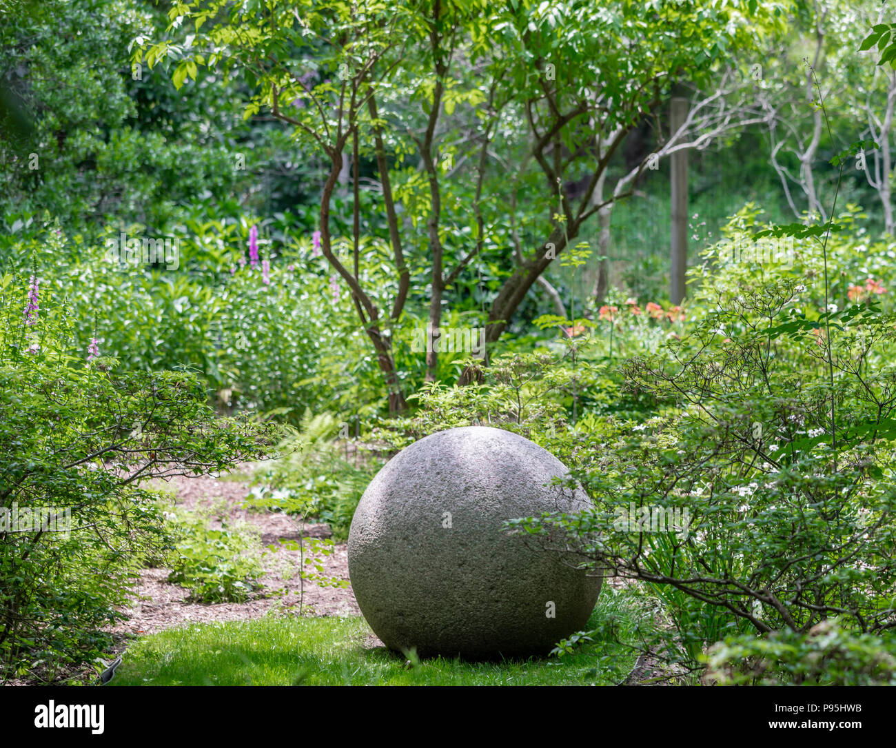 Großen runden Stein in einem gepflegten Hof Stockfoto