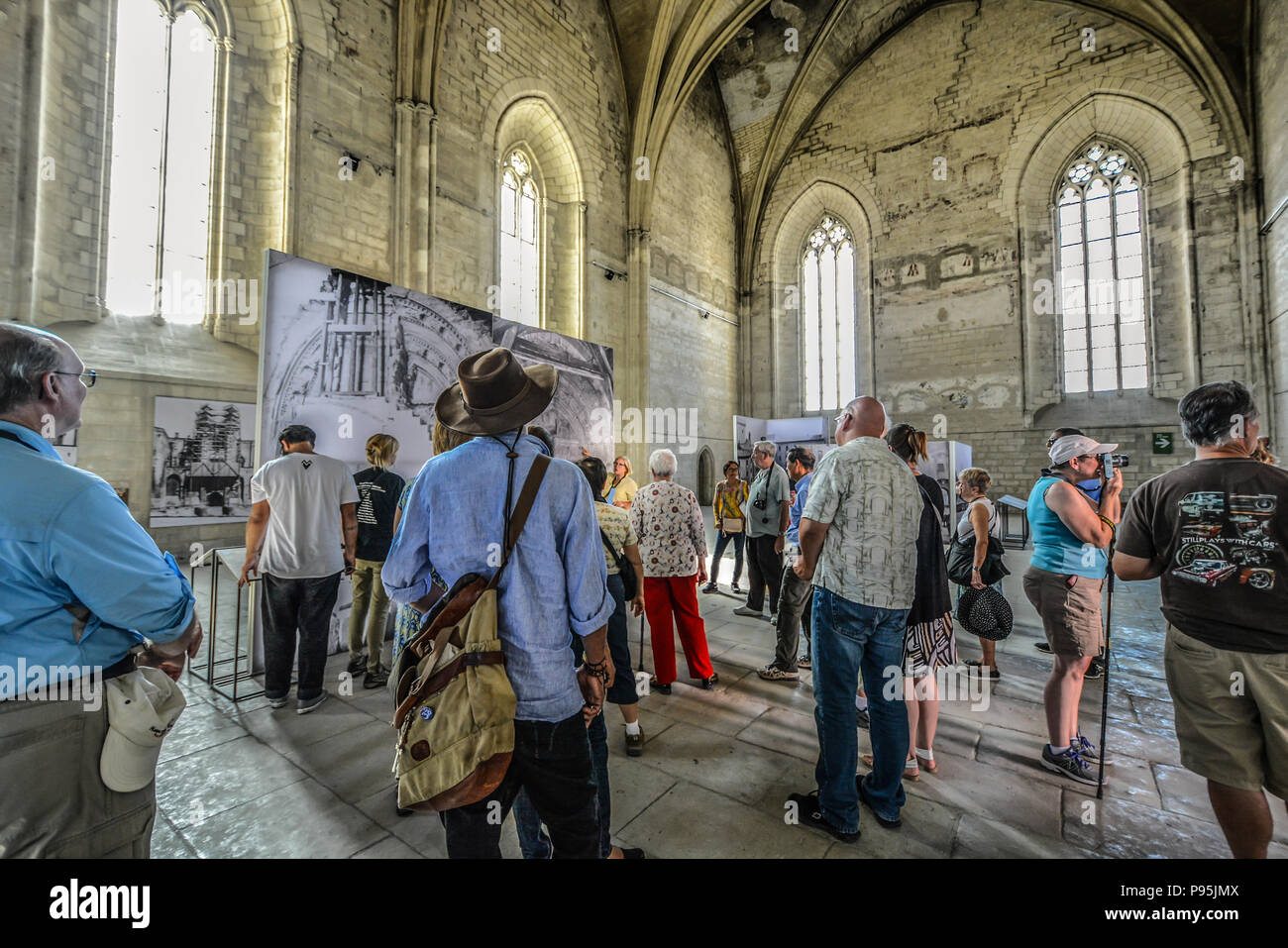 Ein Reiseleiter führt eine Gruppe Touristen durch die alte Kapelle im Palast des Papstes in der Region Provence Avignon, Frankreich. Stockfoto
