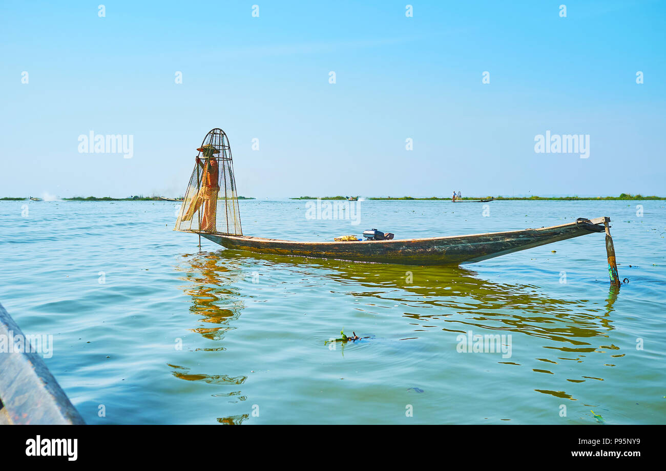 INLE SEE, MYANMAR - 18. FEBRUAR 2018: die so genannte Bein eine Fischer mit konischen Net zeigen traditionelle burmesische Fangtechniken, beliebt auf In Stockfoto