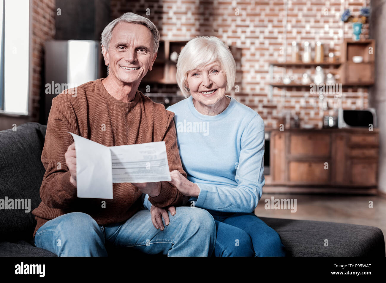 Stattliche Rentner Dokumente in Händen halten. Stockfoto