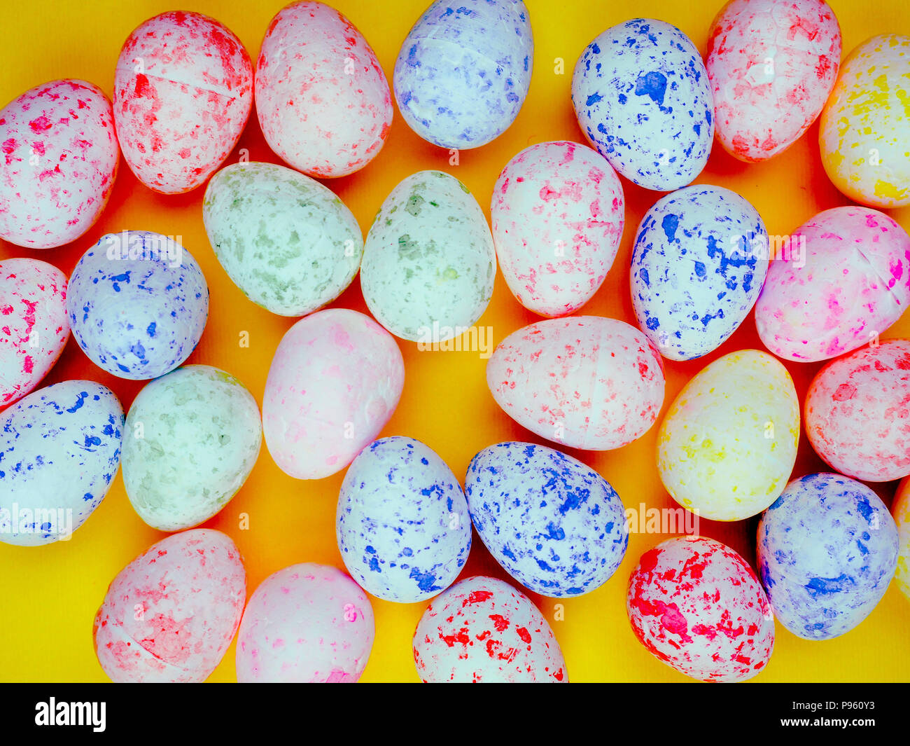 Bunte Eier für das Osterfest auf einem hellen gelben Hintergrund, kopieren Platz für Text, Sonne. Stockfoto