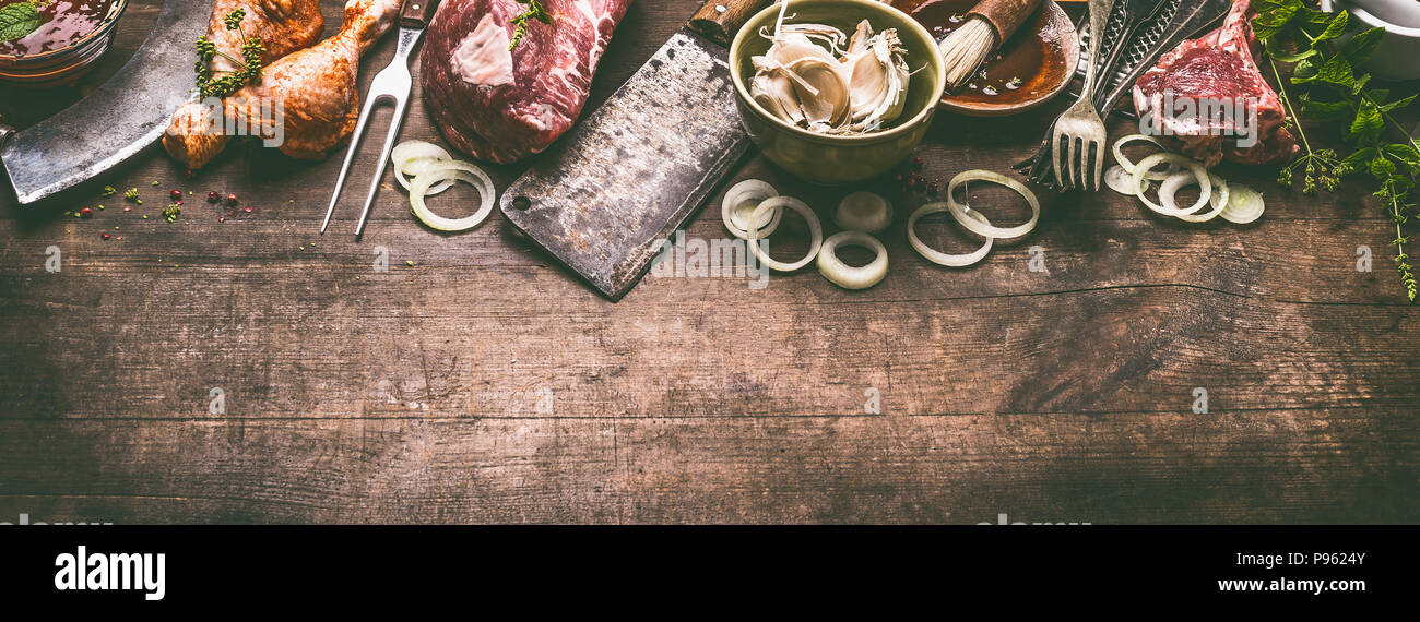 Verschiedenen Grill- und BBQ-Fleisch: Hähnchenschenkel, Steaks, Lamm Rippen mit Vintage Küchenutensilien Küchengeräte: Fleisch Gabel und Metzger Cleaver und Kräuter Messer Stockfoto