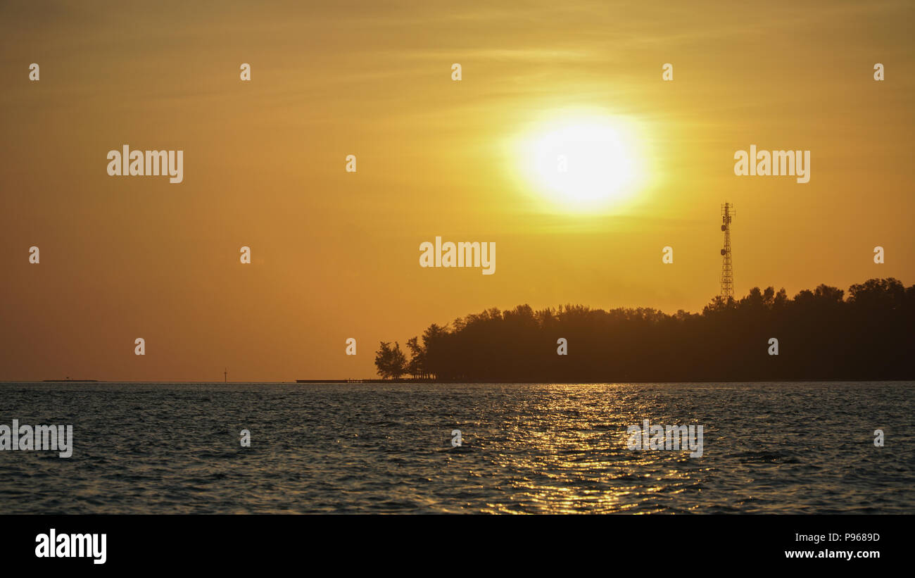 Silhouette einer Insel mit Big Sun bei Sonnenuntergang Stockfoto