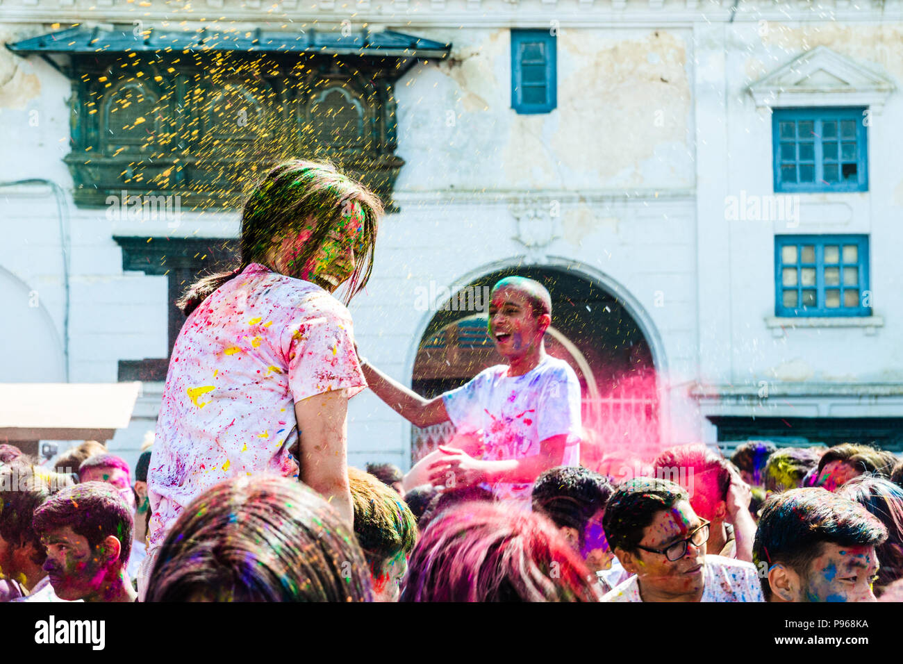 Die Menschen werfen Farbpigmente während Hindu Holi Festival der Farben feiern Basantapur Durbar Square in Kathmandu, Nepal Stockfoto