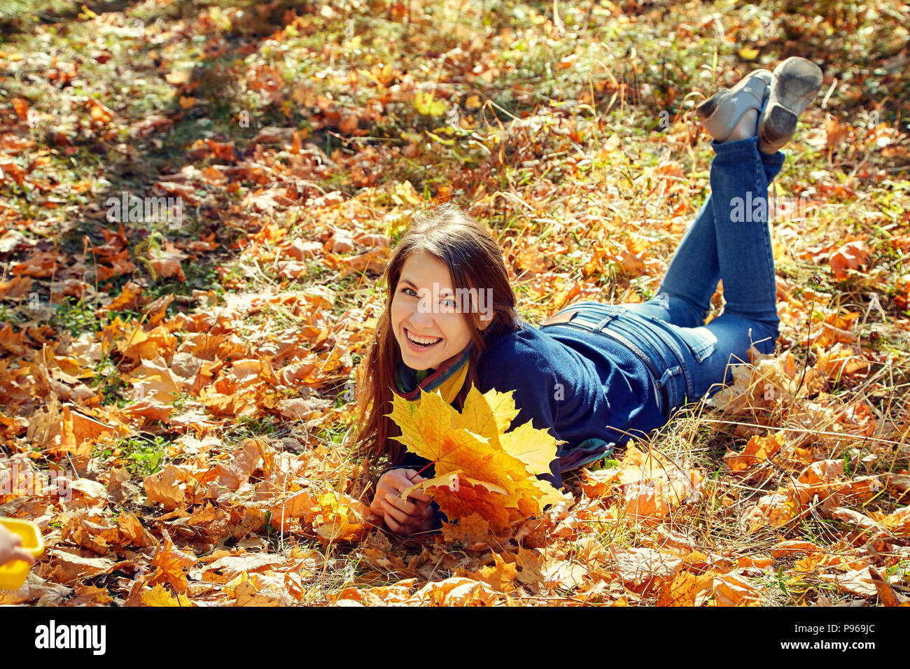 Frau mit gelbem Ahorn Blätter im Herbst Stockfoto