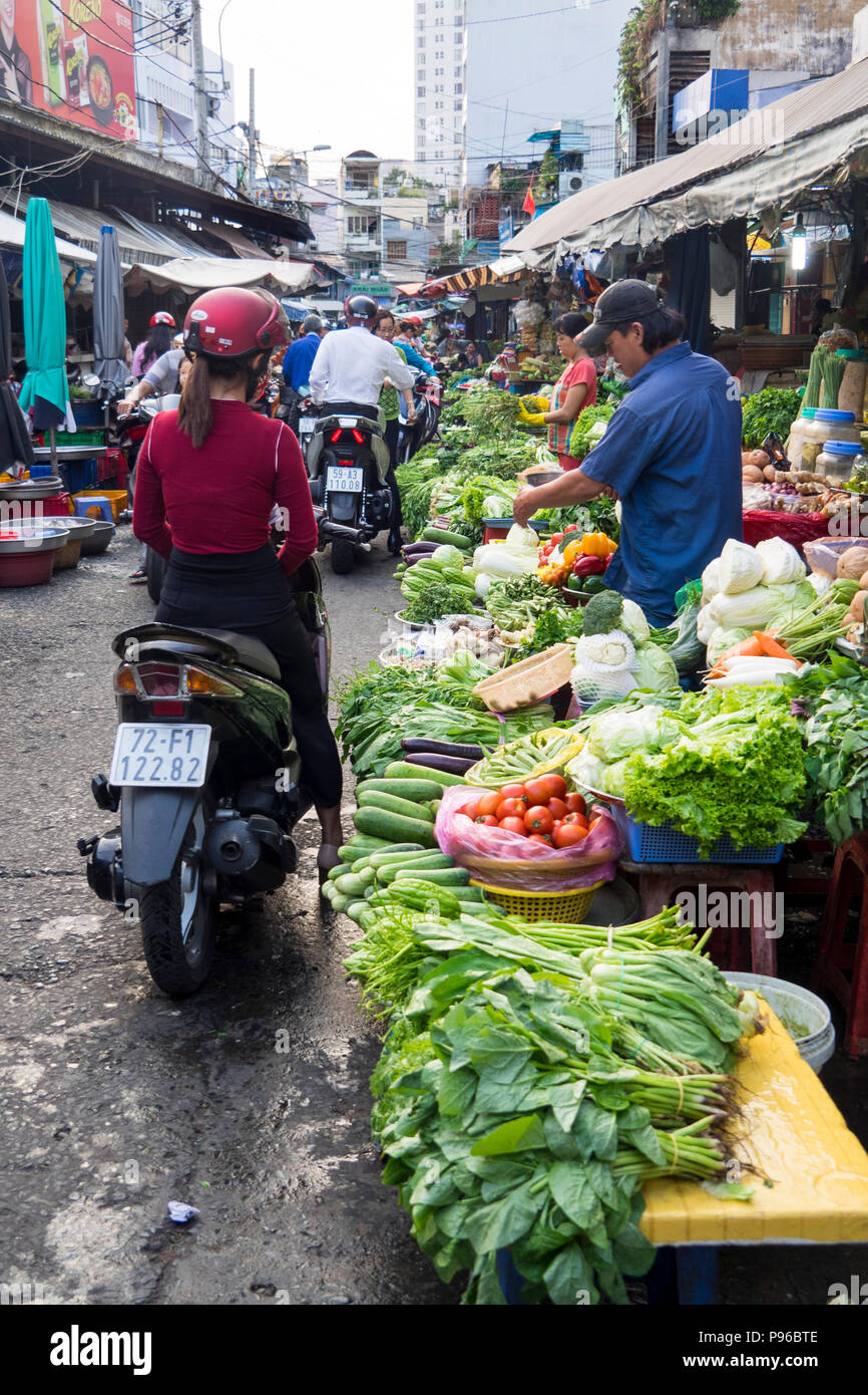 Motorradfahrer kaufen Obst und Gemüse aus einem Markt in der Tan Dinh Markt, Ho Chi Minh City, Vietnam. Stockfoto